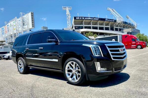 Black car next to a private jet