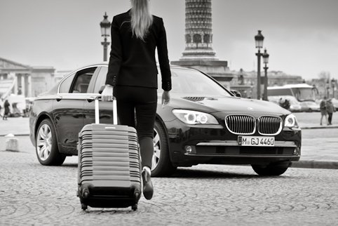 A client with luggage next to a black car
